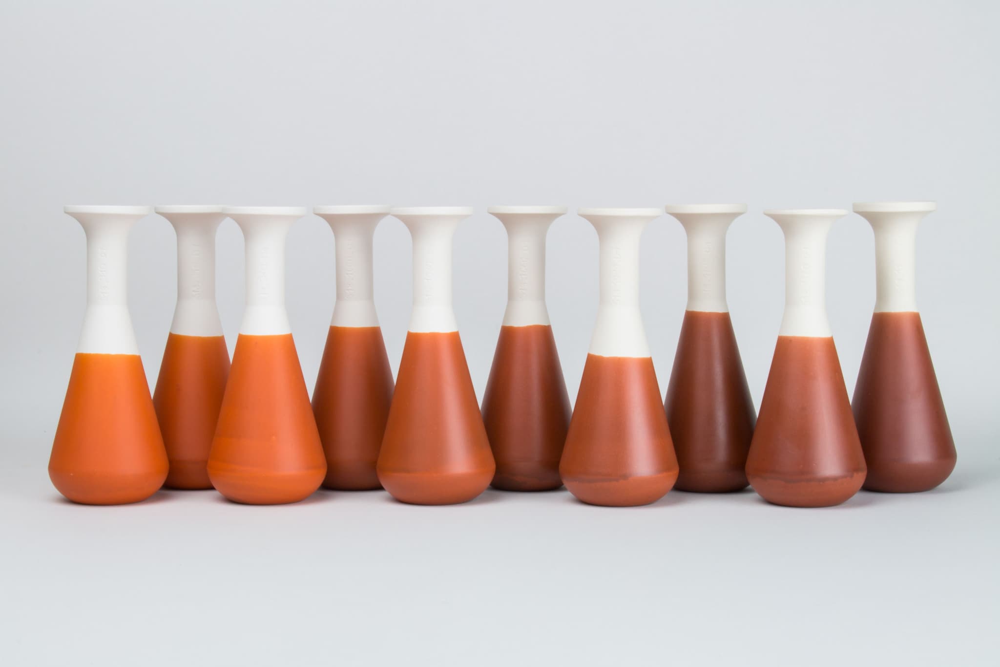 A series of the same terra sigillata on a white body, fired at multiple different temperatures, to find out how it impacts the colour and quality